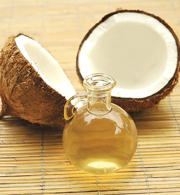 Wood-pressed coconut oil beside fresh coconut halves